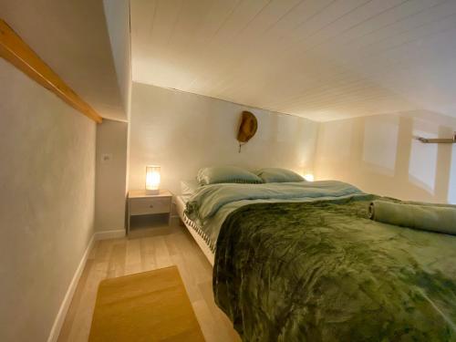 une chambre avec un lit et une lampe sur une table dans l'établissement Charmant loft au cœur de Nimes, à Nîmes