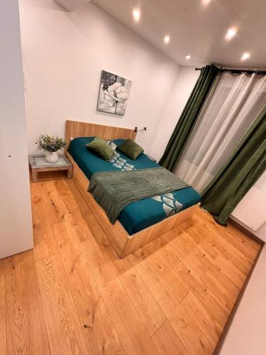 sypialnia z łóżkiem i drewnianą podłogą w obiekcie F2 moderne proche Paris w mieście Alfortville