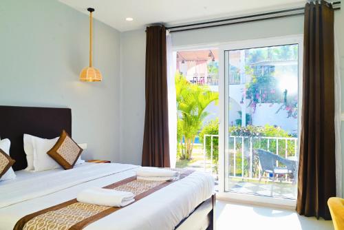 a bedroom with a bed and a large sliding glass door at Tvessa by the Sea in Morjim