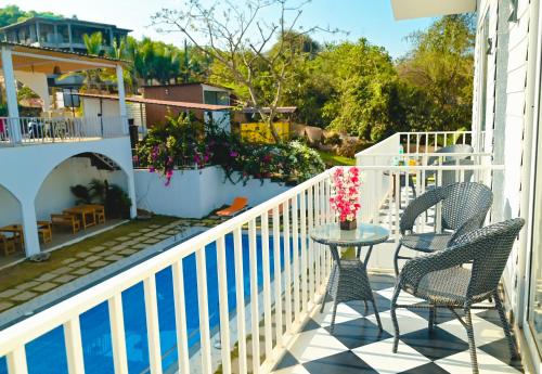 a patio with two chairs and a table on a balcony at Tvessa by the Sea in Morjim