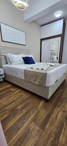 a large bed in a bedroom with a wooden floor at Bahr DELUX App & Suite in Ulcinj