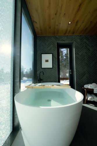 a large white tub in a bathroom with a window at Wilding Hotels Fairbanks in Fairbanks