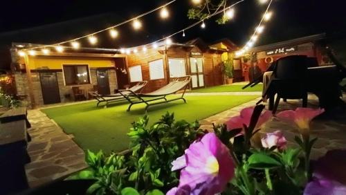 a patio with a lawn with lights and flowers at Mille e una notte in San Severino Lucano