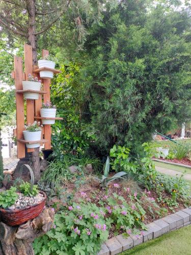 a garden with a bird feeder and some flowers at Vikendica Drinski mir in Loznica