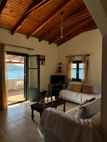 a living room with a couch and a table at Tholos Alexandra's Beachfront House in Kavoúsion