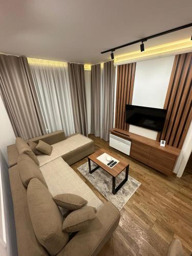 Una sala de estar con un sofá y un televisor. en Tomi Lux, en Zlatibor