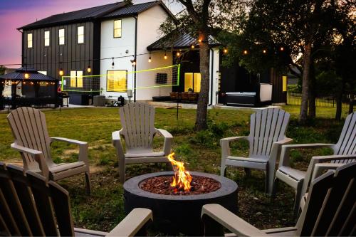 a group of chairs around a fire pit in a yard at Designer Home with Hot Tub BBQ & Hill Views in Driftwood