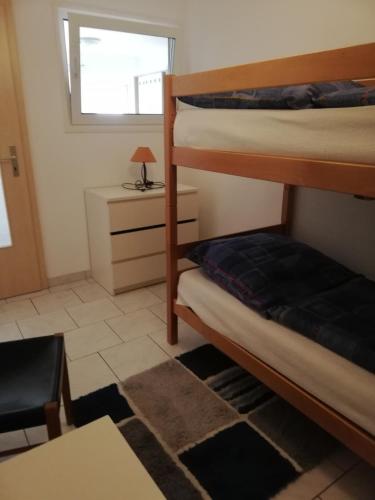 a room with two bunk beds and a desk at Ferienwohnung am Bodensee- Preiswert in Überlingen