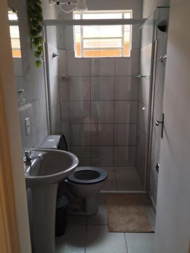 a bathroom with a shower and a toilet and a sink at Casa com 01 qto 42m2 in Poços de Caldas