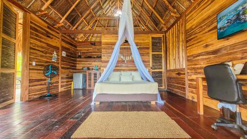 ein Schlafzimmer mit einem Bett in einem Zimmer mit Holzwänden in der Unterkunft Cabaña vista al mar y jacuzzi privado in Los Naranjos