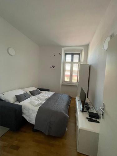a bedroom with a bed and a desk with a computer at Barbabianca Apartment in Koper