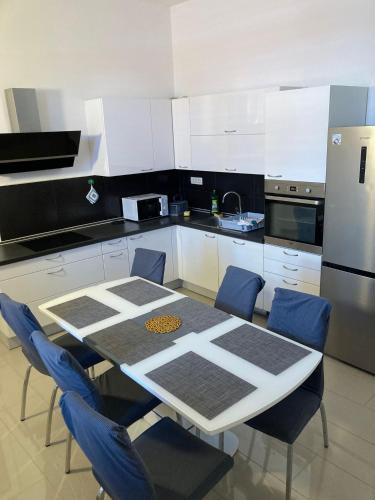 a kitchen with a table and chairs and a refrigerator at Barbabianca Apartment in Koper