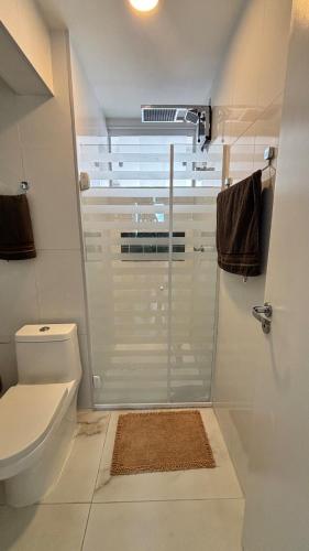 a bathroom with a toilet and a glass shower at Luxury 3 minutes from the Porto da Barra beach - Fast Wi-Fi, new apartment in Salvador