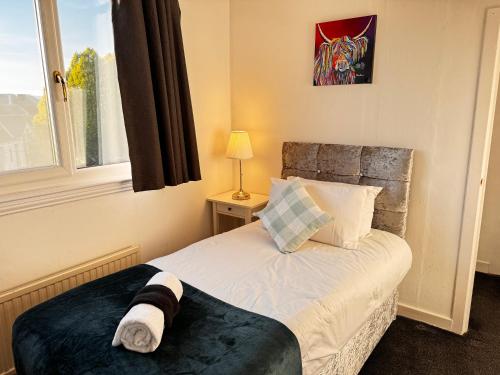 a bedroom with a bed and a window at Wellesley Apartment in Leven-Fife