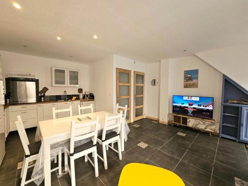 Il comprend une cuisine et une salle à manger avec une table et une télévision. dans l'établissement Maison de ville authentique au coeur de Leucate, à Leucate