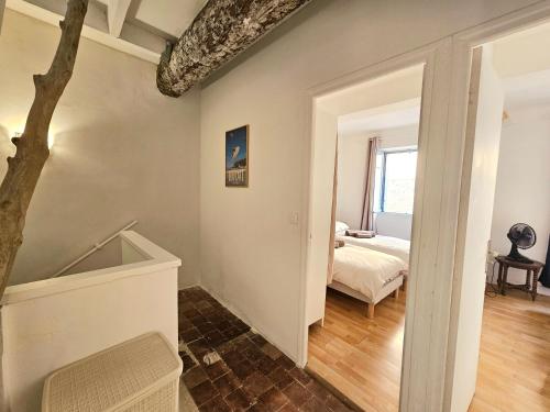 Cette chambre comprend un lit et un arbre. dans l'établissement Maison de ville authentique au coeur de Leucate, à Leucate