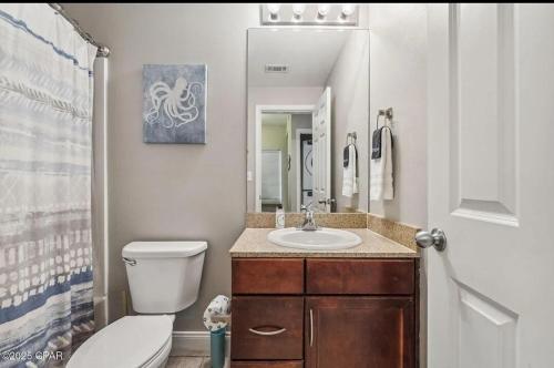 a bathroom with a toilet and a sink and a mirror at The Crab's Eyebrow in Panama City Beach