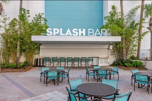 a patio with tables and chairs in front of a splash bar at The Crab's Eyebrow in Panama City Beach