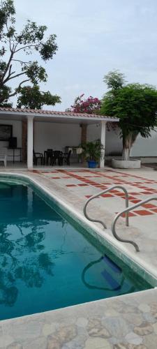 a swimming pool in front of a house at Villa Roy in Santa Marta