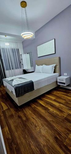 a bedroom with a large bed and a wooden floor at Bahr DELUX App & Suite in Ulcinj
