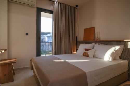 una camera da letto con un letto grande con una grande finestra di Casa Olivea a Polykhrono