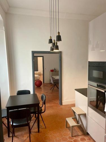 une cuisine et une salle à manger avec une table et des chaises dans l'établissement 120 m2, hyper centre cathédrale proximité plage, à Ajaccio