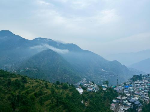 a view of a mountain with a city in the foreground at Queens Hill by Edge Mussoorie in Mussoorie