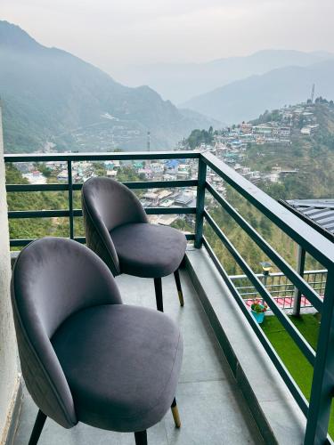 two chairs sitting on top of a balcony at Queens Hill by Edge Mussoorie in Mussoorie
