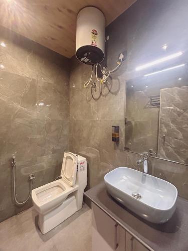a bathroom with a toilet and a sink at Queens Hill by Edge Mussoorie in Mussoorie