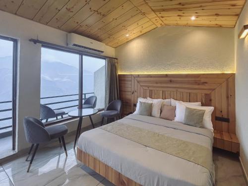 a bedroom with a bed and a large window at Queens Hill by Edge Mussoorie in Mussoorie