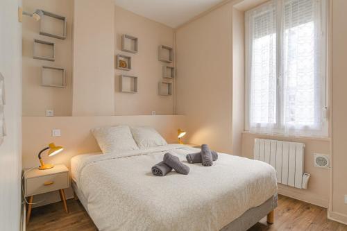 une chambre avec un lit avec deux serviettes dessus dans l'établissement La Pause Lyonnaise, à Lyon