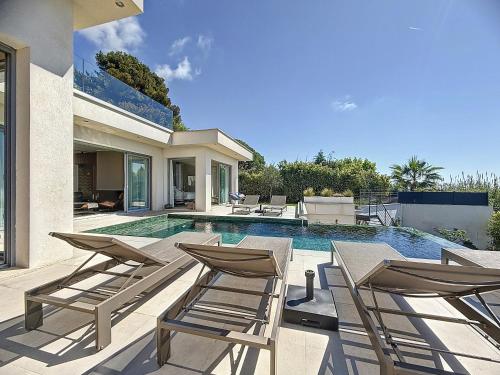 une piscine avec des chaises et une maison dans l'établissement Villa Prestige et Vue Mer, à Tourrettes-sur-Loup