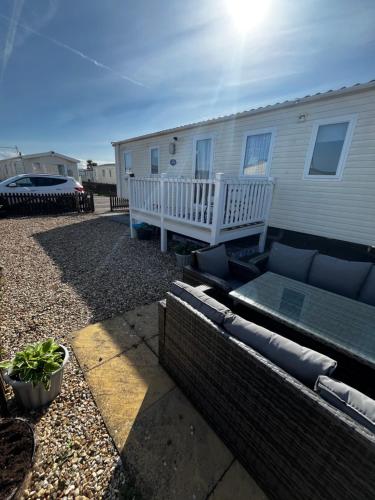 a house with a patio and a couch in a yard at 163 Holiday Resort Unity Brean sands Pet friendly in Berrow