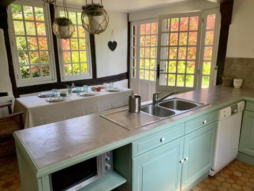 une cuisine avec un évier et un plan de travail dans l'établissement Chaumière du Val, à Triqueville