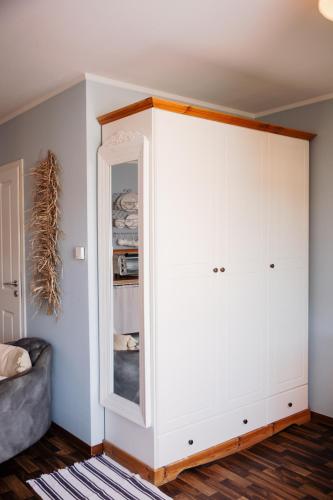 a large white cabinet with a mirror in a room at Pension Adele - Ruhig, direkt am Elberadweg & Badesee mit Balkon in Dresden