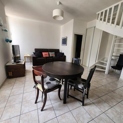 un salon avec une table, des chaises et un canapé dans l'établissement Appartement a deux pas de la Promenade des Anglais, à Nice