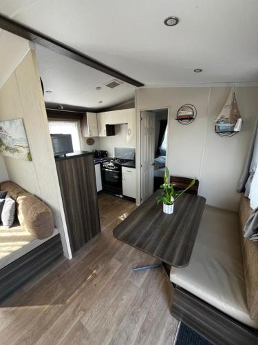 a living room with a table in a tiny house at 163 Holiday Resort Unity Brean sands Pet friendly in Berrow