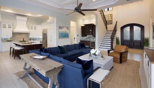 a living room with a blue couch and a table at Hollyhock in Marco Island