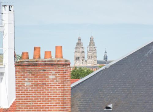 a brick chimneys on top of a roof with buildings in the background at Cocon Caféiné in Tours