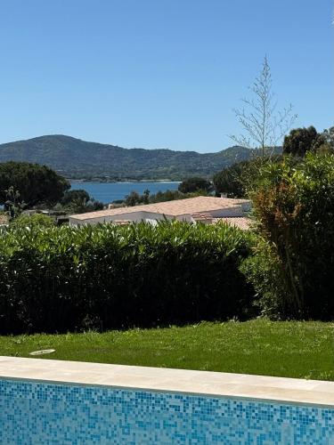 une piscine avec vue sur un plan d'eau dans l'établissement Magnifique villa vue mer avec piscine et plage privée, à Grimaud