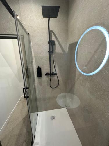 a shower with a round mirror in a bathroom at 27 côté remparts in Aigues-Mortes