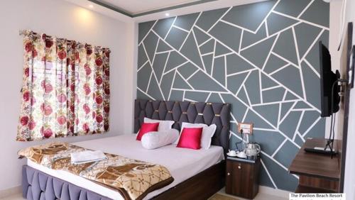 The Pavilion Beach Resort في Jāmb: غرفة نوم بسرير كبير مع وسائد حمراء