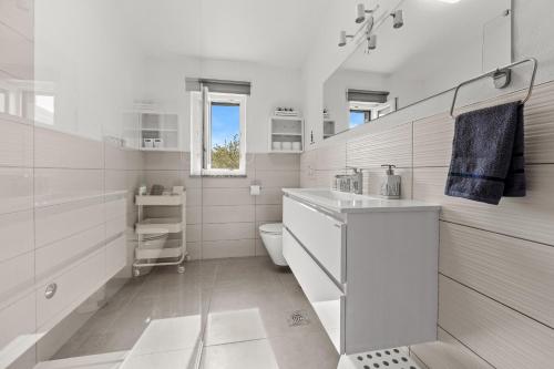 a white bathroom with a sink and a toilet at House Kacana in Vodnjan