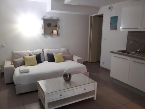 un salon avec un canapé blanc et une table dans l'établissement Grand Studio - Proche place de la Comédie, à Montpellier