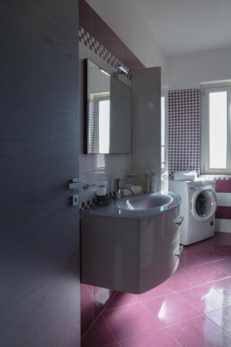 a bathroom with a sink and a washing machine at Casetta Ficara in Altomonte