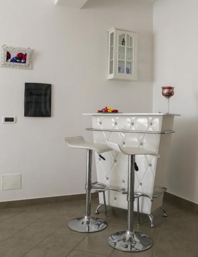 a white bar with stools in a white wall at Casetta Ficara in Altomonte