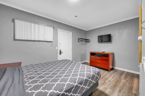 WoodhavenにあるPrivate Stay for 2 • Near Food Fun Spotsのベッドルーム(ベッド1台、ドレッサー、テレビ付)