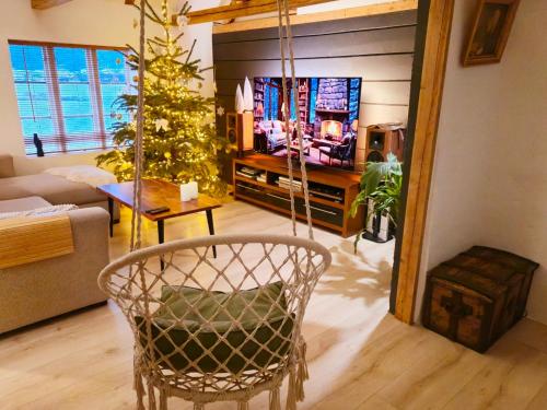 a living room with a chair and a christmas tree at OAH 1870 Oldest Alesund House in Ålesund