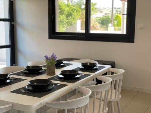 a dining room table with black bowls and chairs at Casa Posidonia in Korinthos