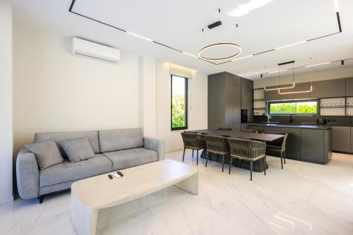 a living room with a couch and a table at SanPietro Premium Villas in Draçi